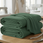 Zwei gefaltete grüne KraftKids Wandpaneel abgerundet Doppelkrepp-Stoffbolzen liegen auf einem Holztisch mit einem Maßband in der Nähe - ideal für Ihr nächstes kreatives Projekt in der Wandgestaltung oder für gepolsterte Wandpaneele.