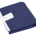 Die KraftKids Reisewickelunterlage Leinen blau dunkelblau ist eine sauber gefaltete dunkelblaue Wickelunterlage mit weißem Rand und Gurt - ideal als platzsparende Wickelunterlage oder Reiseauflage Baby. Ausgestellt auf einem weißen Hintergrund.