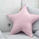 Das Sternkissen Doppelkrepp Rosa von KraftKids liegt auf grauen Kissen eines hellgrauen Sofas und verleiht dem Kinderzimmer eine gemütliche, minimalistische Atmosphäre.