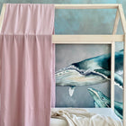 Eine KraftKids Bettbaldachin Doppelkrepp Rosa hängt über einem hölzernen Himmelbett vor einem Wal-Wandbild, mit einer beigen Decke auf dem Bett - charmante Kinderzimmer Deko für kleine Träumer.