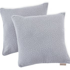 Zwei quadratische KraftKids Kissenbezüge Musselin in Grau mit weißen Tupfen sind auf weißem Hintergrund gestapelt, einer leicht überlappend, mit einem sichtbaren Stoffanhänger. Ideal zur Aufwertung jeder Bettwäsche-Kollektion.